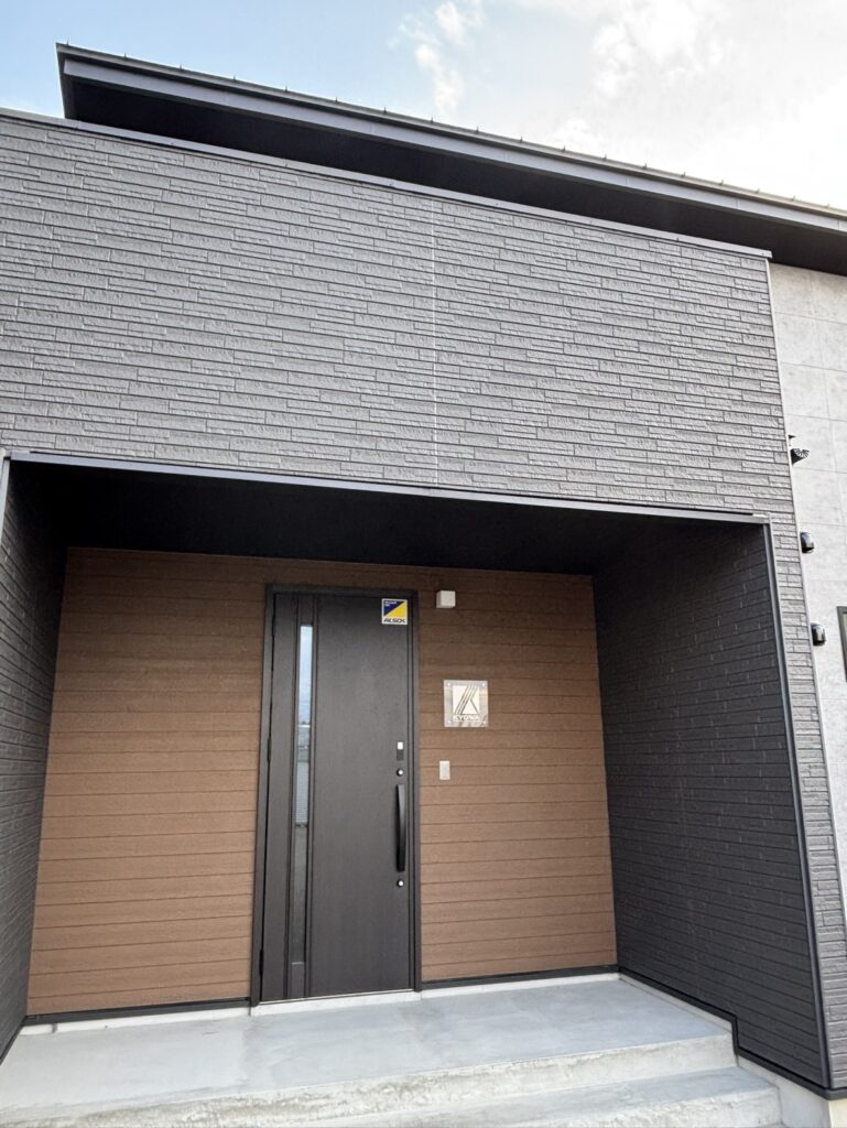 グレーの外壁と木目調の壁を組み合わせた建物入口